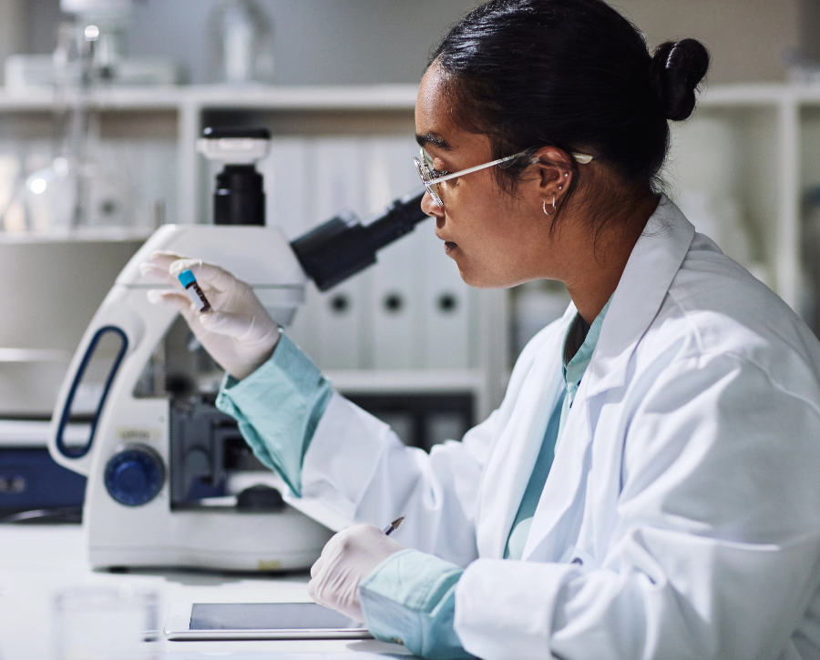 A female scientist in a lab, staring at a blood sample