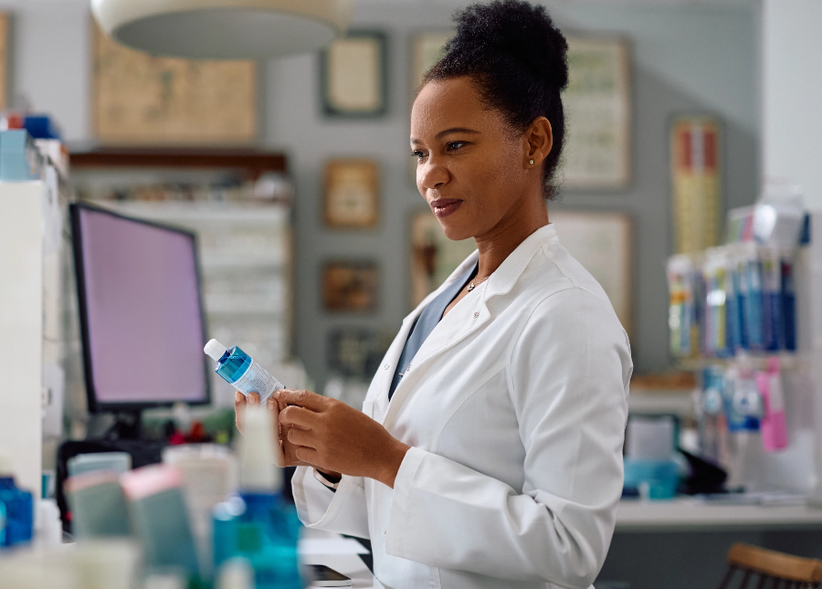 Pharmacist looking at the information on the bottle.